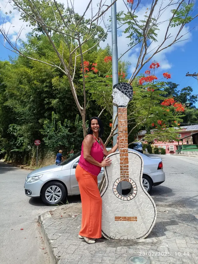 Visitante junto a monumento em forma de violão em Conservatória
